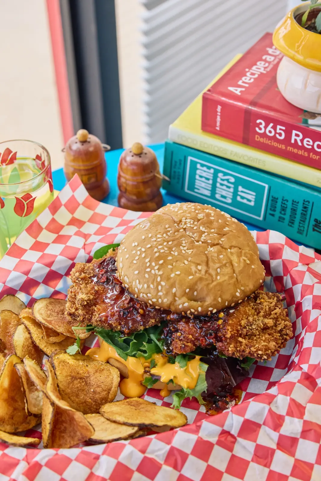 Fried chicken sandwich and house chips in a gingham basket